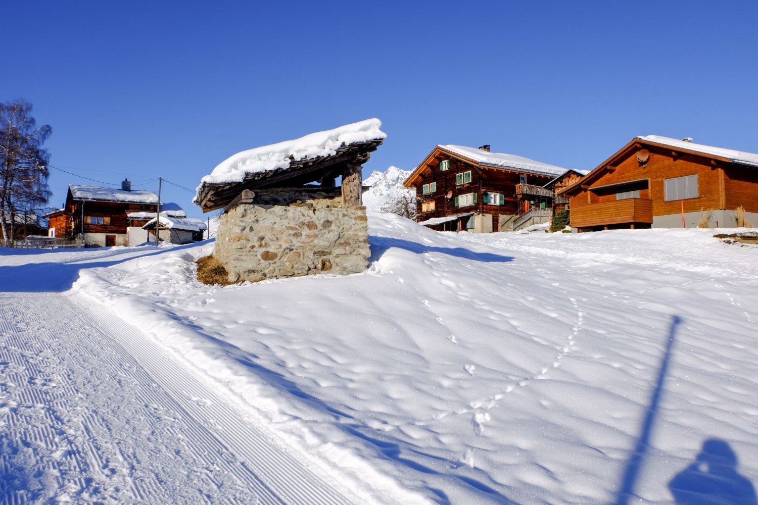 Die Winterwanderung streift den Weiler Giraniga. Traditionelle und neue Baukultur geben sich hier die Hand. Im Vordergrund ein Ofenhaus.