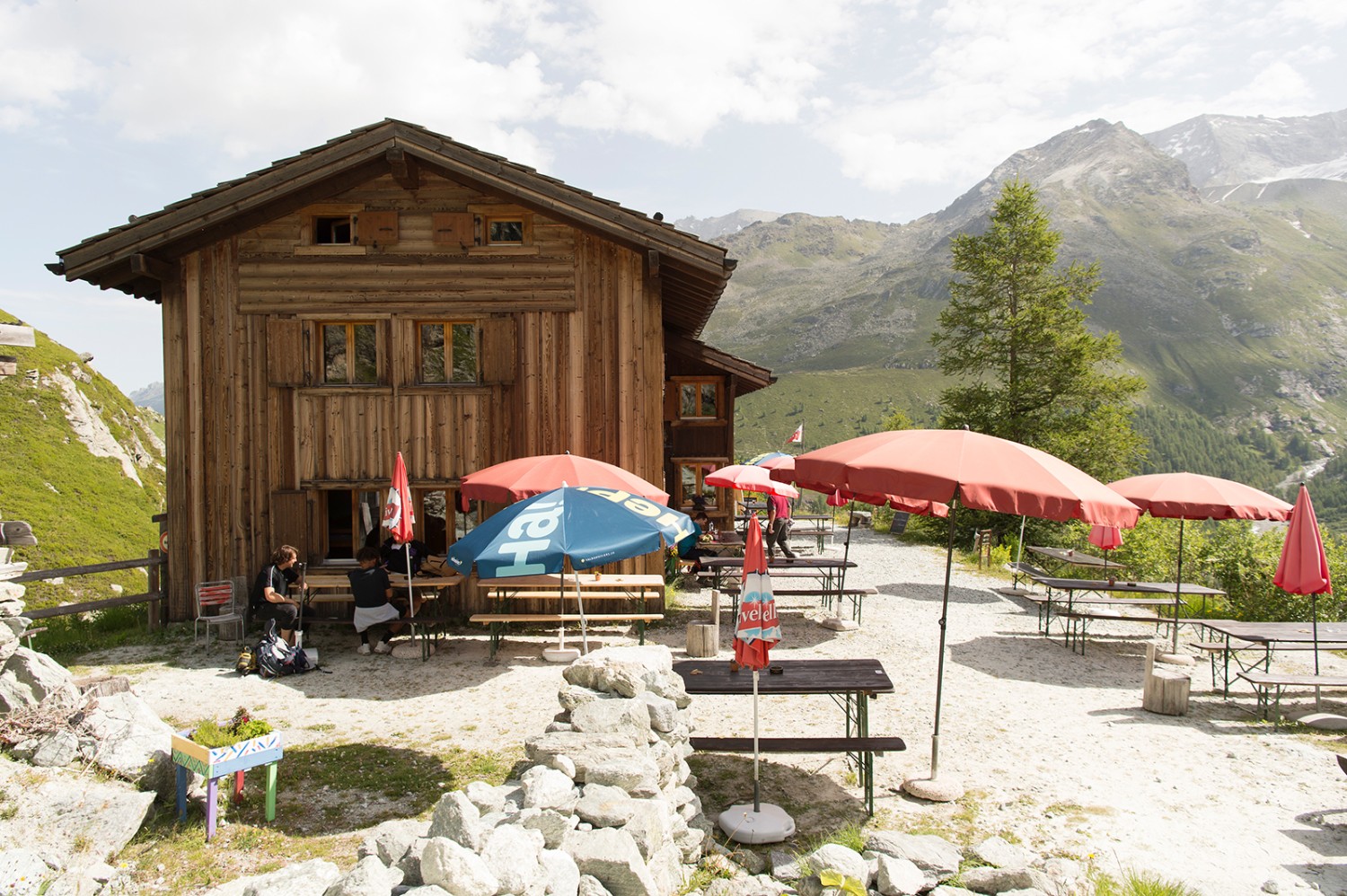 Auf der Terrasse der Berghütte geniessen die Grossen den Ausblick, während die Kleinen herumtoben können.